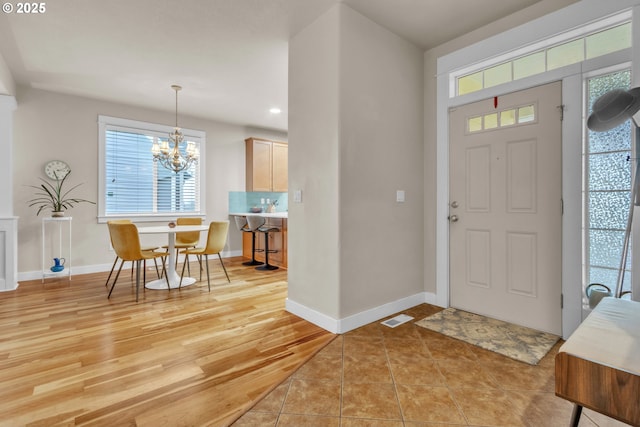 entrance foyer with a chandelier, baseboards, light wood-type flooring, and recessed lighting