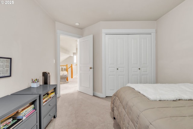 bedroom featuring light carpet, a closet, and baseboards