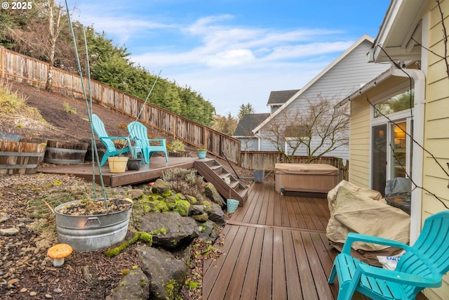 wooden deck featuring a hot tub and a fenced backyard