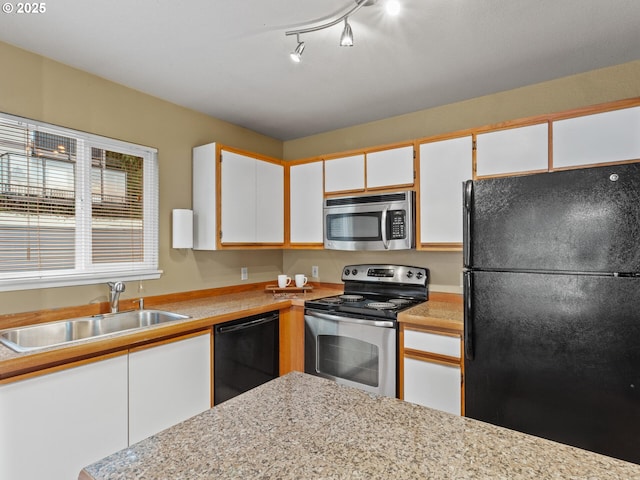 kitchen featuring black appliances, white cabinetry, track lighting, and sink