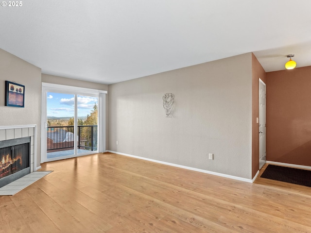 unfurnished living room featuring light wood-type flooring and a fireplace