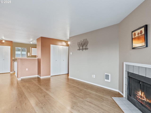 unfurnished living room featuring a fireplace and light wood-type flooring