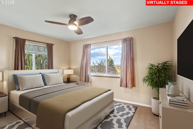 carpeted bedroom featuring ceiling fan and multiple windows