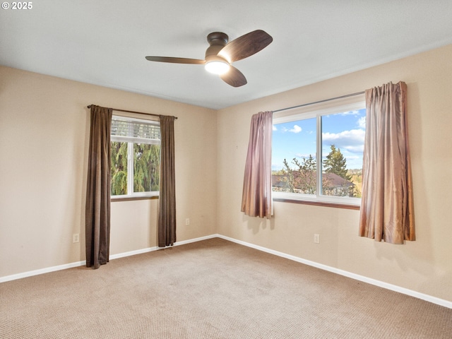 spare room featuring carpet flooring, ceiling fan, and a wealth of natural light