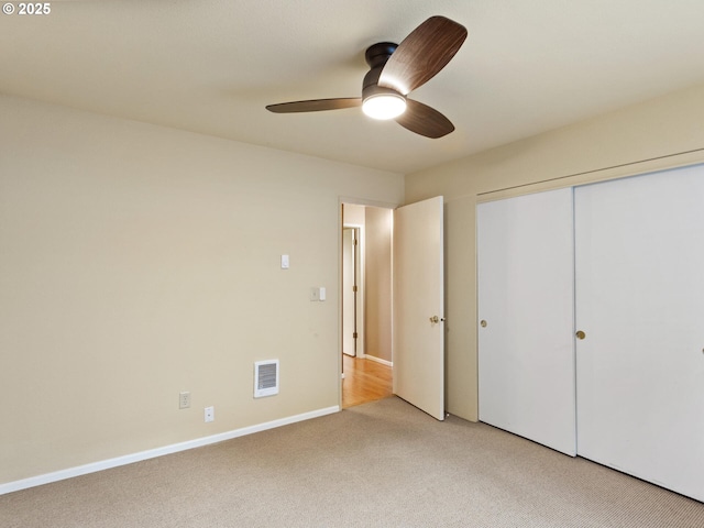 unfurnished bedroom featuring ceiling fan, a closet, and carpet