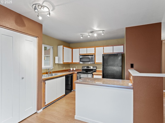 kitchen featuring sink, white cabinets, and black appliances