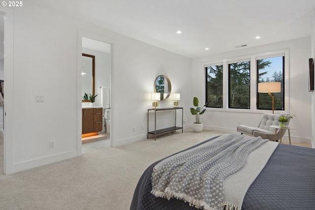 bedroom featuring light colored carpet and ensuite bath