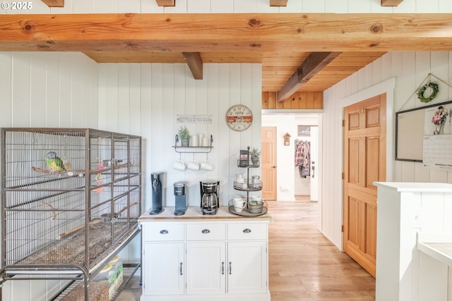 182 Holloway Hts, Brownsville, OR 97327 - kitchen with light wood finished floors, a wooden ceiling with exposed beams, white cabinets, wooden walls, and light countertops