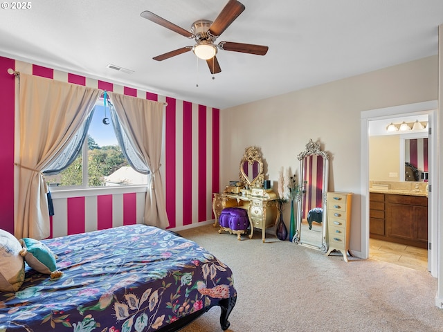 bedroom featuring ceiling fan, ensuite bath, and light carpet