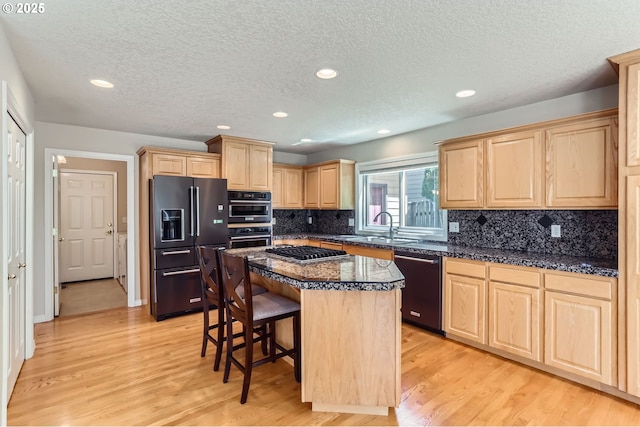 10939 SE Valley Way, Happy Valley, OR 97086 - kitchen with fridge with ice dispenser, black dishwasher, light brown cabinets, stainless steel gas cooktop, and a kitchen bar