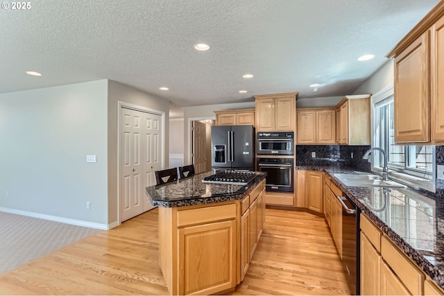 10939 SE Valley Way, Happy Valley, OR 97086 - kitchen featuring appliances with stainless steel finishes, a kitchen island, light brown cabinets, light wood finished floors, and recessed lighting