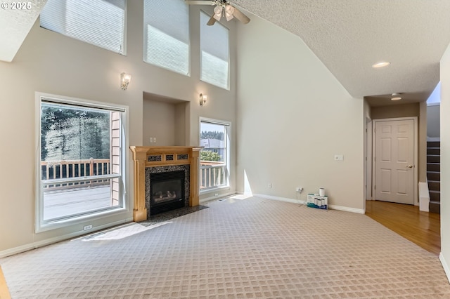10939 SE Valley Way, Happy Valley, OR 97086 - unfurnished living room featuring a fireplace, plenty of natural light, high vaulted ceiling, ceiling fan, and carpet flooring