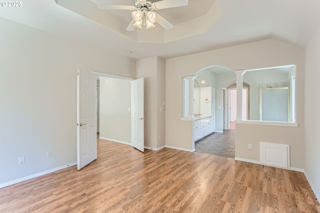 10939 SE Valley Way, Happy Valley, OR 97086 - unfurnished room featuring arched walkways, a ceiling fan, light wood-style floors, ornate columns, and a raised ceiling
