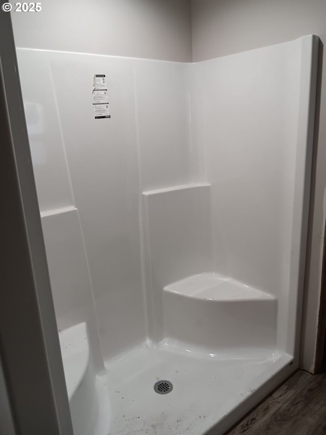 full bath with wood finished floors and walk in shower