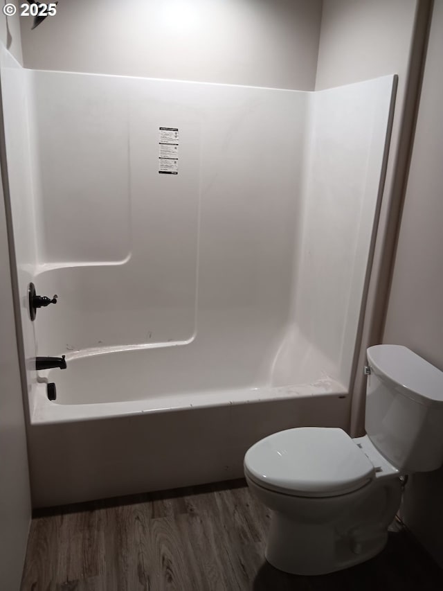 full bath with toilet, wood finished floors, and shower / bath combination