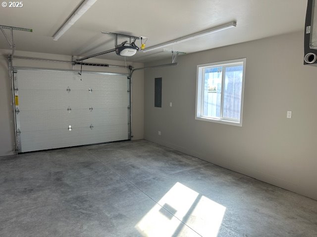 garage featuring electric panel and a garage door opener