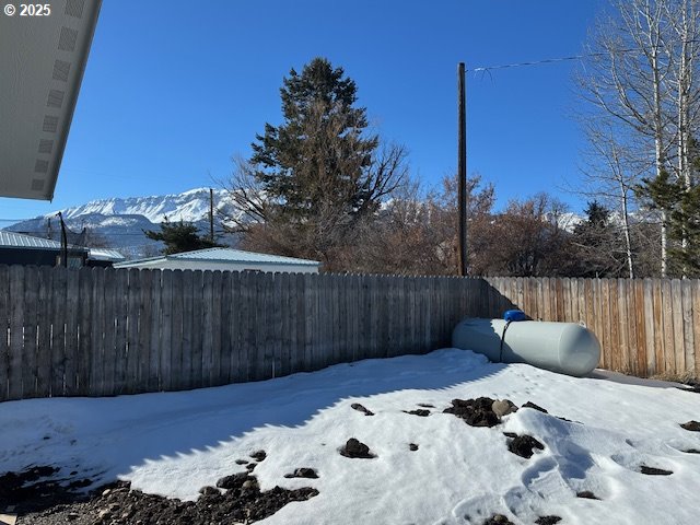 yard layered in snow featuring a fenced backyard