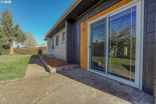 view of side of property featuring a lawn and a patio