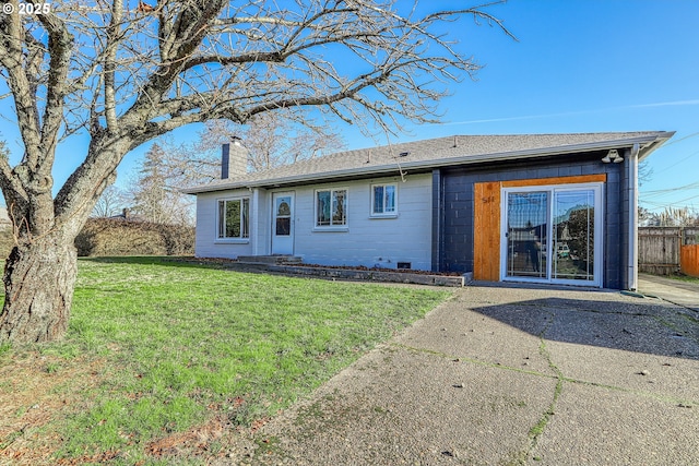 view of front of house with a shingled roof, a front yard, fence, and a chimney