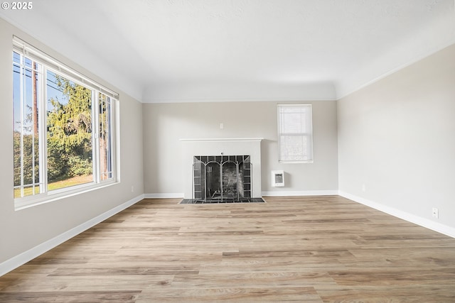 unfurnished living room with heating unit and light hardwood / wood-style floors