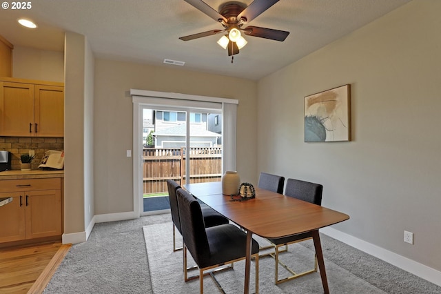 dining area featuring ceiling fan, baseboards, and light carpet
