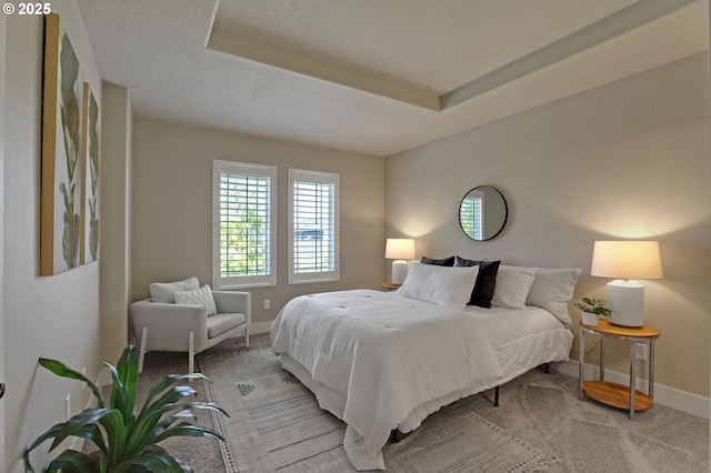 bedroom featuring baseboards, light colored carpet, and a textured ceiling