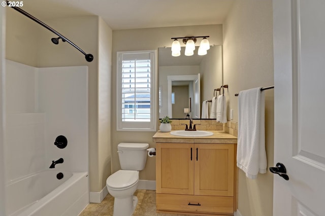 bathroom with toilet, vanity, shower / tub combination, backsplash, and baseboards