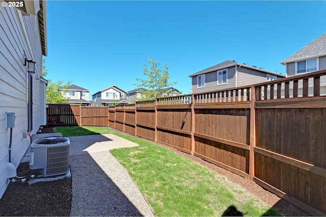fenced backyard featuring cooling unit and a residential view