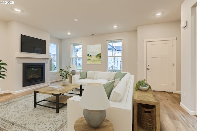 865 Legacy St, Eugene, OR 97402 - living room with light wood-style flooring, a glass covered fireplace, baseboards, and recessed lighting