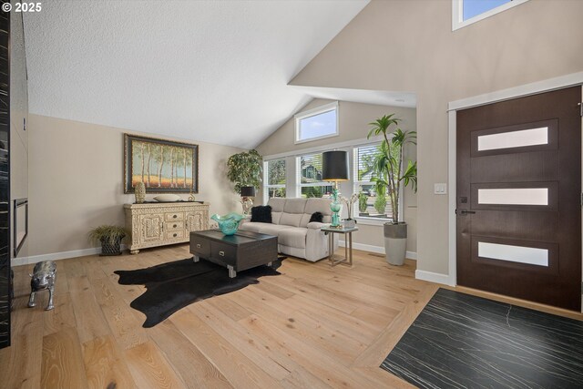 15525 SW Hearth Ct, Beaverton, OR 97007 - entrance foyer featuring high vaulted ceiling, light wood-type flooring, and baseboards