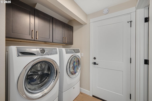 15525 SW Hearth Ct, Beaverton, OR 97007 - washroom with separate washer and dryer, cabinet space, light wood-type flooring, and baseboards