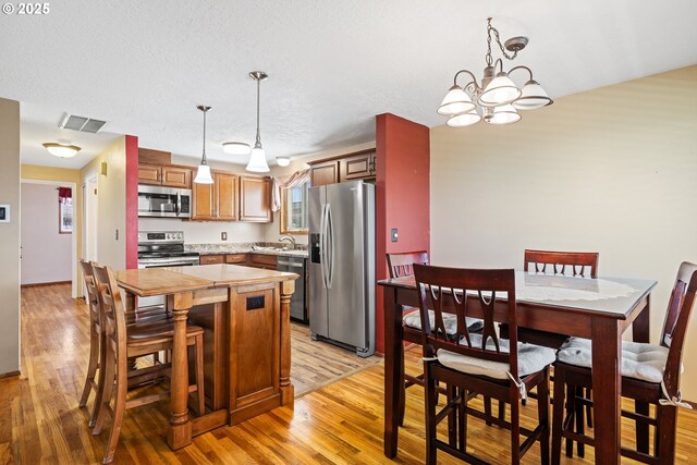 kitchen featuring a chandelier, light countertops, visible vents, appliances with stainless steel finishes, and a sink