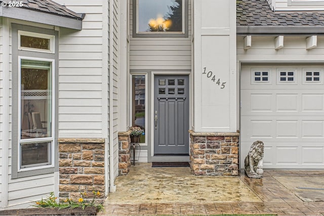10445 SW 141st Ave, Beaverton, OR 97008 - property entrance with stone siding, roof with shingles, and a garage