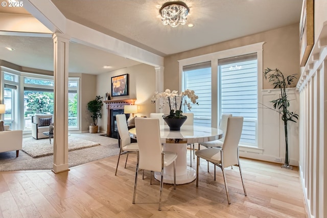 10445 SW 141st Ave, Beaverton, OR 97008 - dining space with a fireplace with flush hearth, decorative columns, light wood-style floors, and recessed lighting