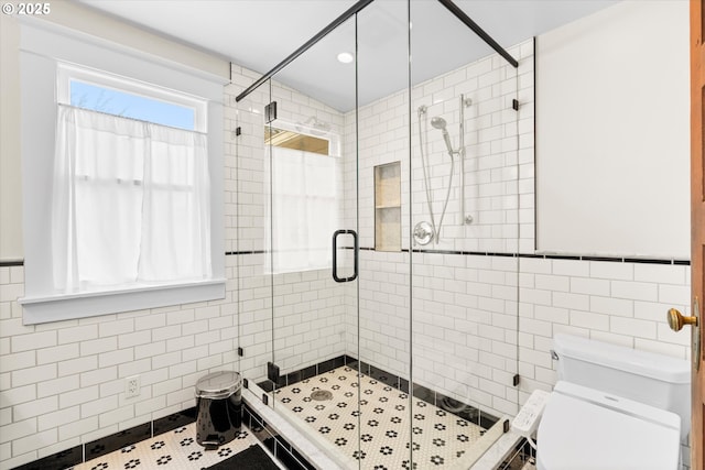 full bath with tile walls, toilet, a stall shower, recessed lighting, and tile patterned floors