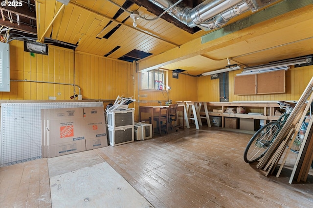 misc room with hardwood / wood-style flooring, wooden walls, and a workshop area
