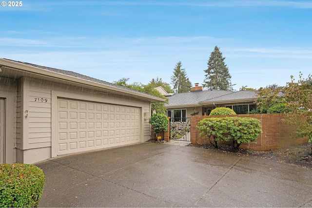 single story home with a garage, fence, and a gate