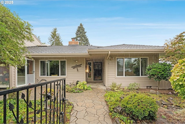 single story home with a chimney and a shingled roof