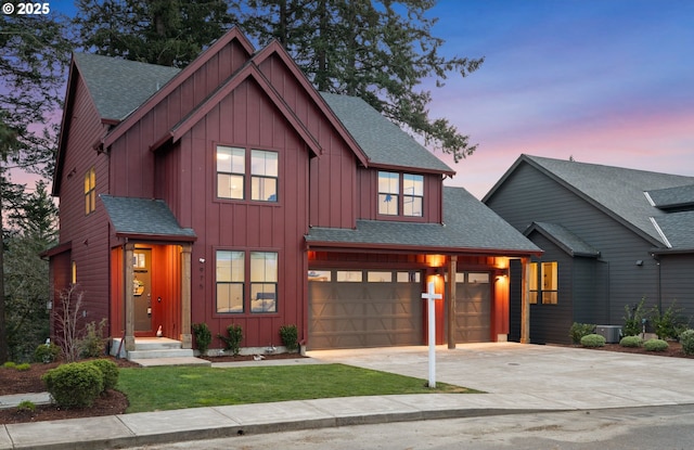 modern inspired farmhouse with board and batten siding, a shingled roof, driveway, and an attached garage