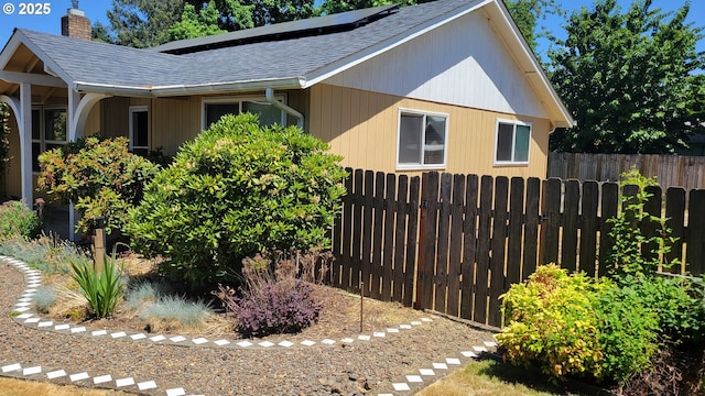 3623 Marion St SE, Albany, OR 97322 - view of property exterior with a shingled roof, a chimney, and roof mounted solar panels