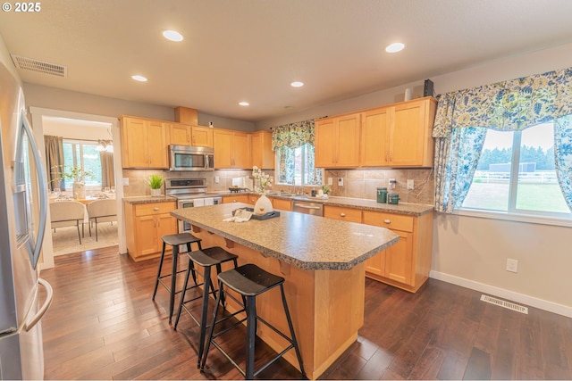 29115 NE 99th Ave, Battle Ground, WA 98604 - kitchen with appliances with stainless steel finishes, light brown cabinetry, light countertops, dark wood-style floors, and a center island