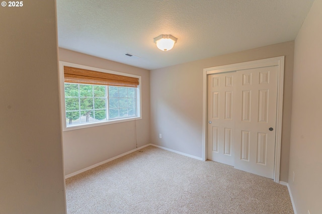 29115 NE 99th Ave, Battle Ground, WA 98604 - unfurnished bedroom featuring carpet flooring, a closet, baseboards, and a textured ceiling