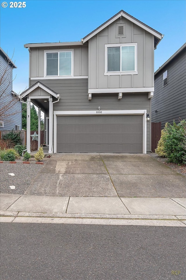 view of front of house with board and batten siding, concrete driveway, fence, and an attached garage