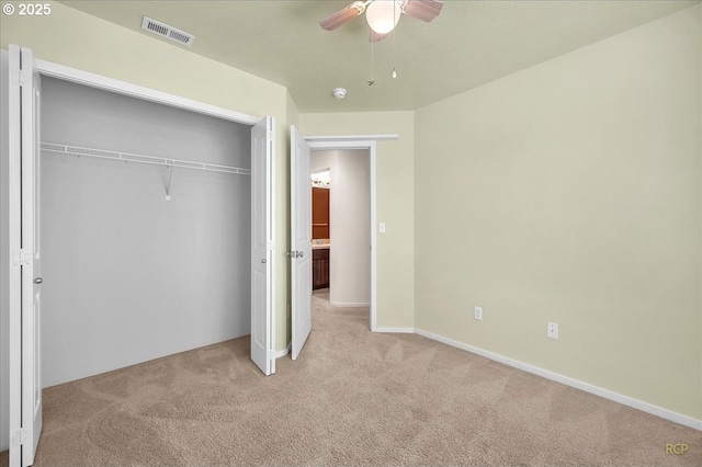 unfurnished bedroom with a closet, visible vents, a ceiling fan, light carpet, and baseboards