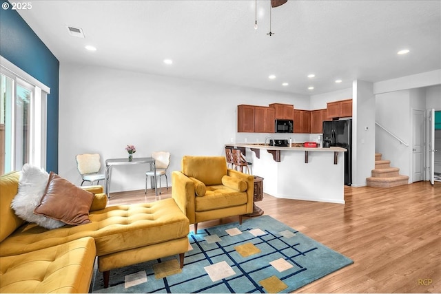 living room with light wood finished floors, stairway, visible vents, and recessed lighting