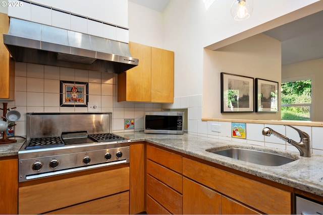 2941 SW Moss St, Portland, OR 97219 - kitchen featuring appliances with stainless steel finishes, range hood, a sink, and decorative backsplash