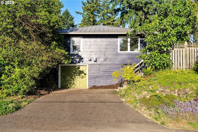 2941 SW Moss St, Portland, OR 97219 - view of property exterior with an attached garage, concrete driveway, metal roof, and a standing seam roof