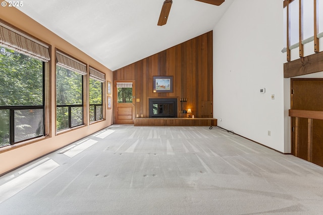 2 Icarus Loop, Lake Oswego, OR 97035 - unfurnished living room with wood walls, high vaulted ceiling, ceiling fan, carpet, and a glass covered fireplace