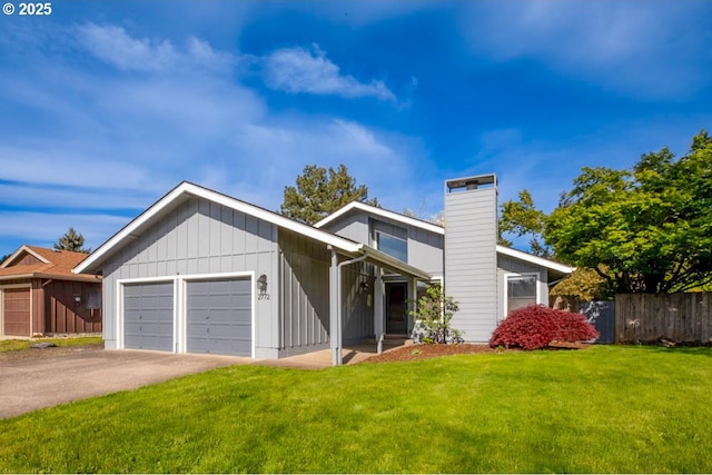 mid-century modern home with fence, a front lawn, aphalt driveway, a garage, and a chimney