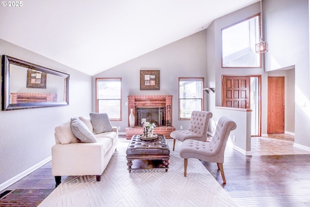 living room featuring visible vents, a brick fireplace, wood finished floors, baseboards, and high vaulted ceiling